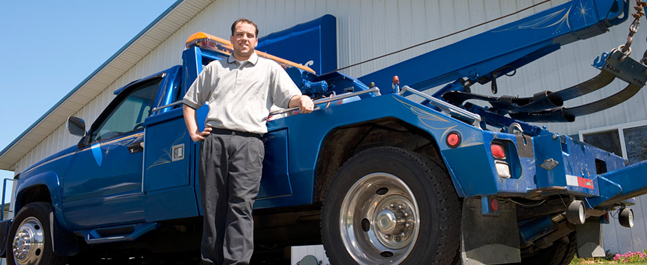 Berrier Insurance Reviews Image Man standing at his blue tow truck